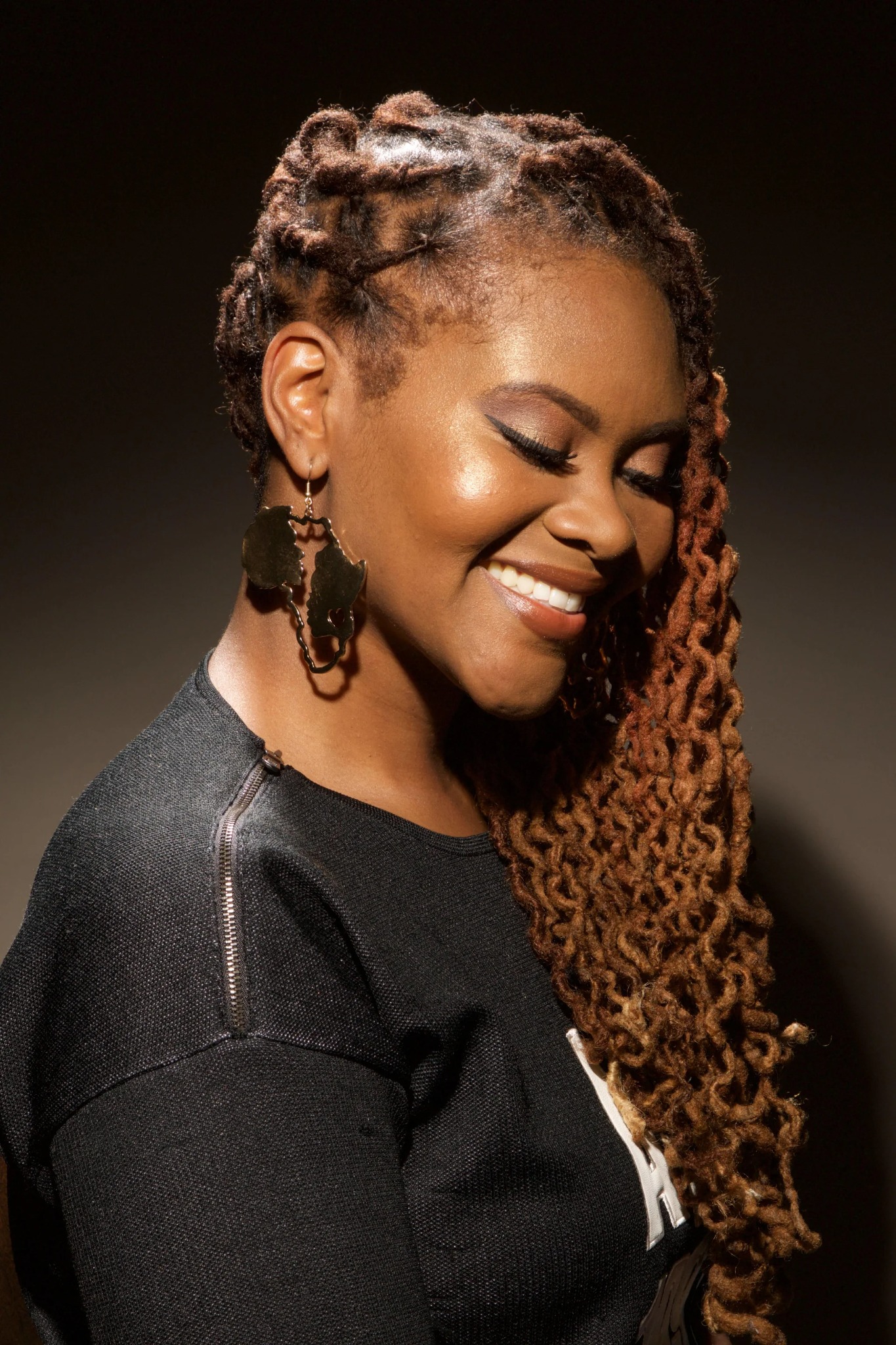 Interlocked locs with warm color and a side-swept style